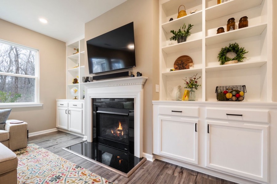 TV mounted above a gas fireplace with a soundbar on the mantel and no visible wires