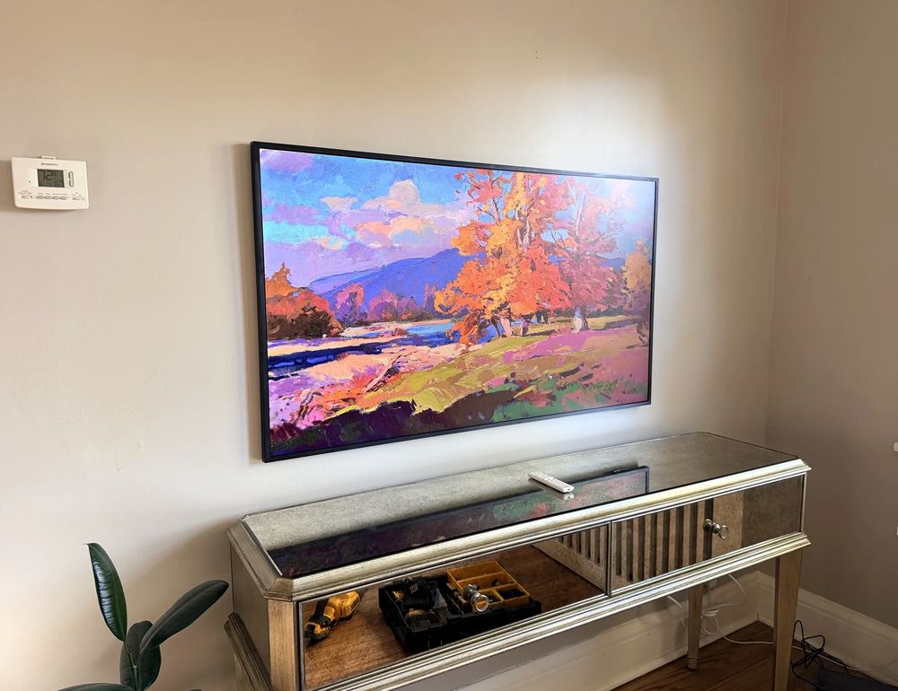 55-inch TV mounted above a mirrored console in Halifax, showing a painting in art mode