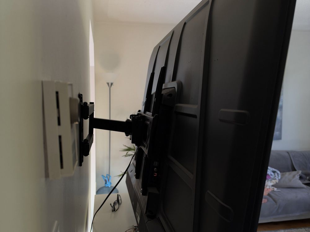 Full-motion TV mount arm extended above a fireplace, Halifax TV mounting