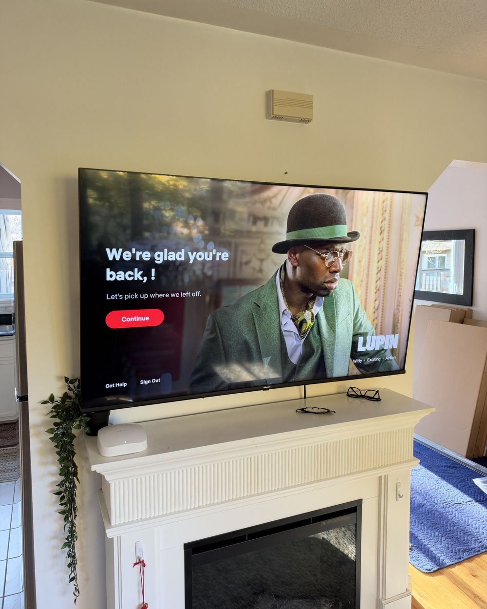 65-inch TV mounted above a white fireplace mantel in Halifax on a full-motion mount, no visible wires