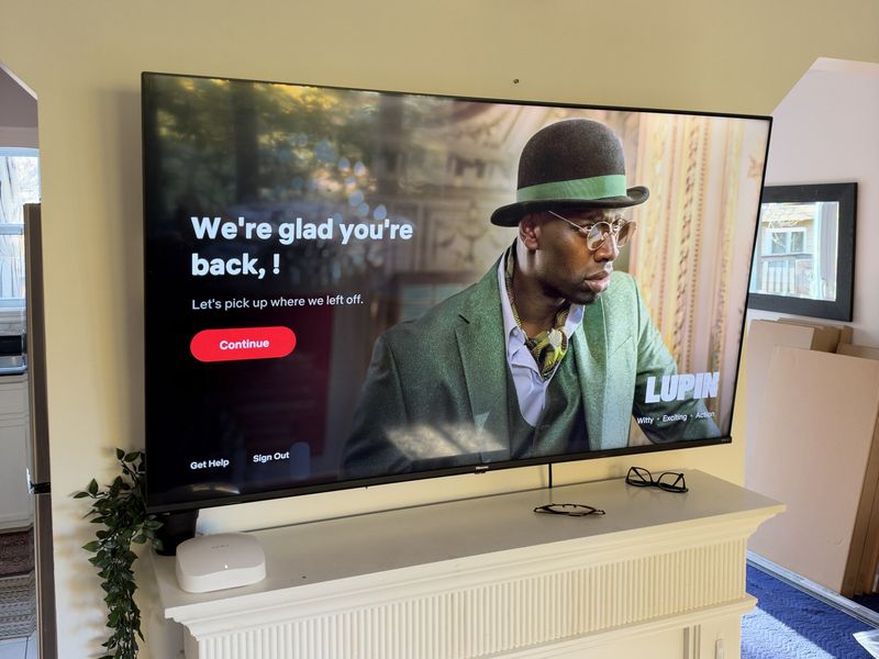 65-inch TV mounted above a white fireplace mantel in Halifax on a full-motion mount, no visible wires