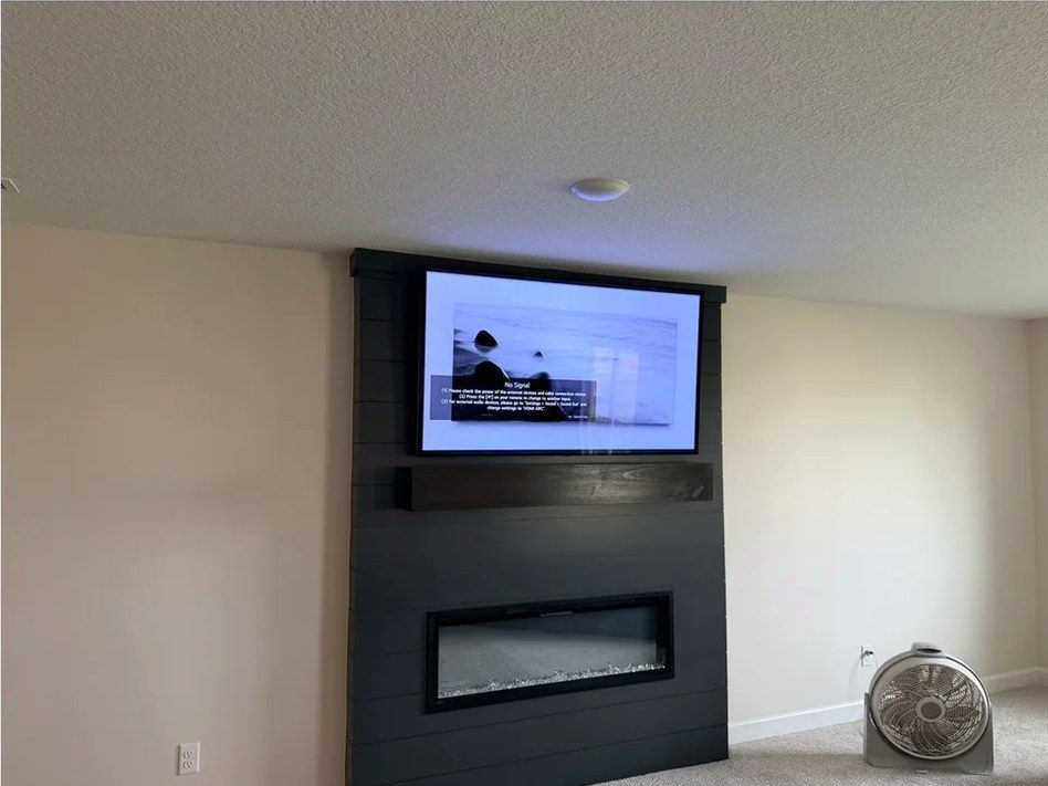 TV above a linear electric fireplace in a basement